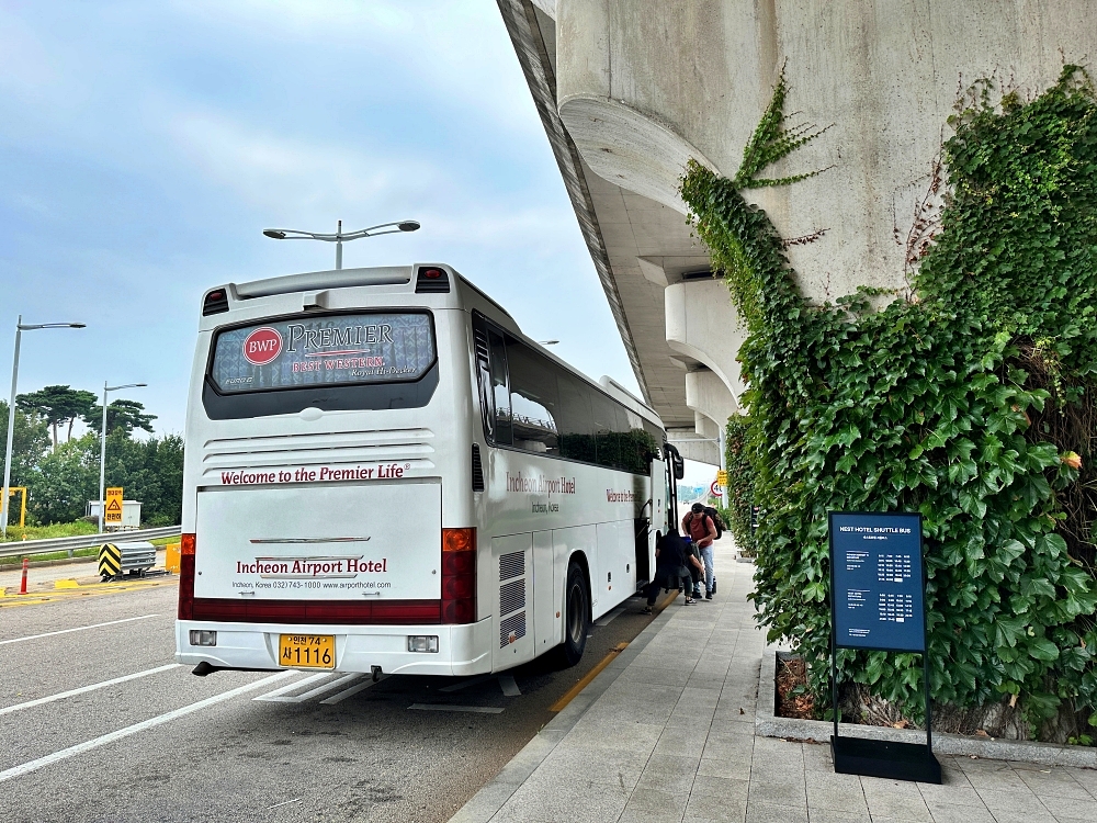 인천공항 1터미널 근처 숙소인 베스트웨스턴 프리미어 호텔을 오고가는 호텔 셔틀 버스. 인천공항 정류장에 정차한 셔틀버스에서 사람들이 내리고 있다.