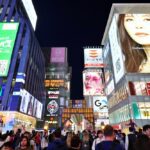 오사카 여행 중심 도톤보리의 밤. 수 많은 사람들과 네온사인이 보인다.