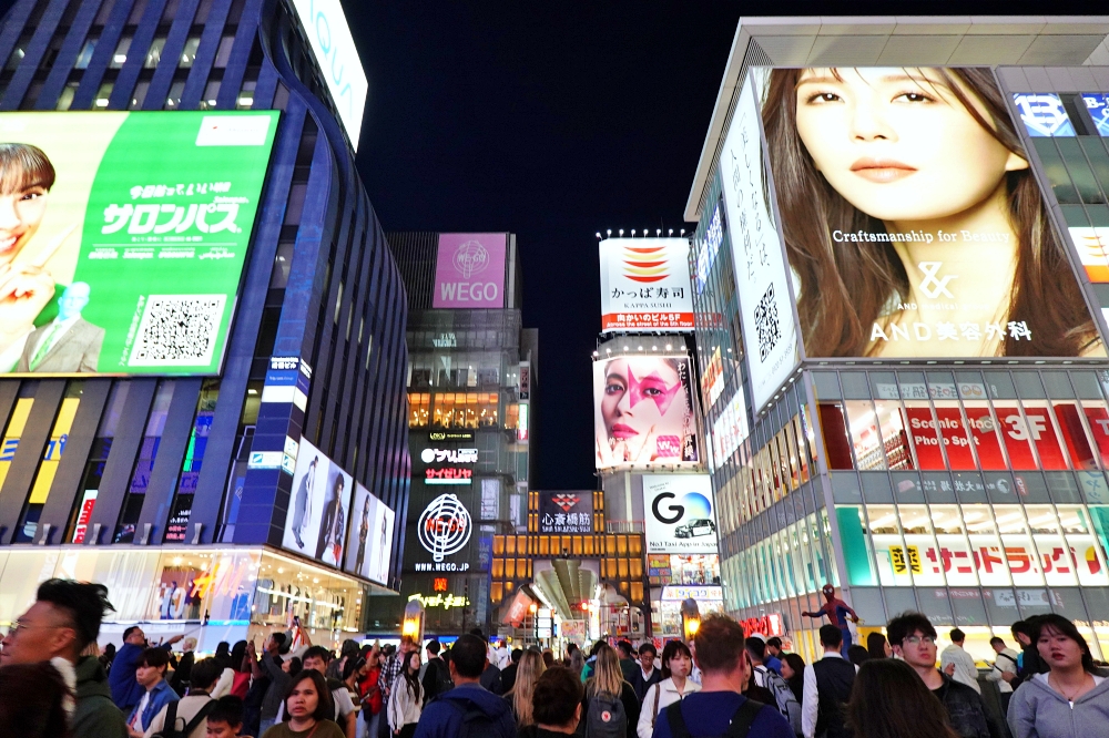오사카 여행 중심 도톤보리의 밤. 수 많은 사람들과 네온사인이 보인다.