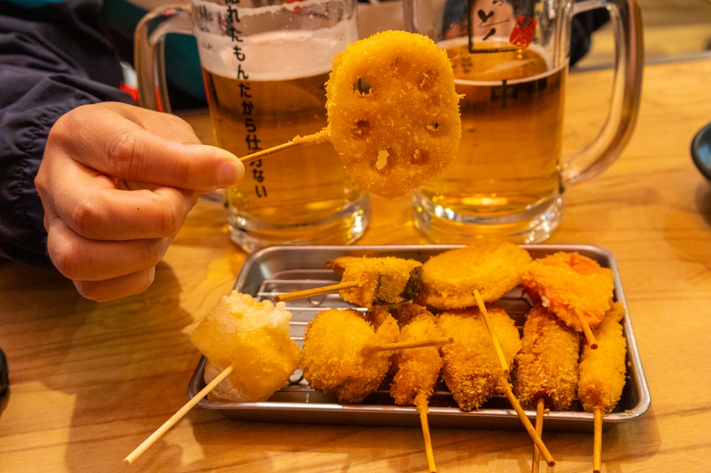 쿠시카츠를 한 남자가 손으로 들고 있는 클로즈업 사진